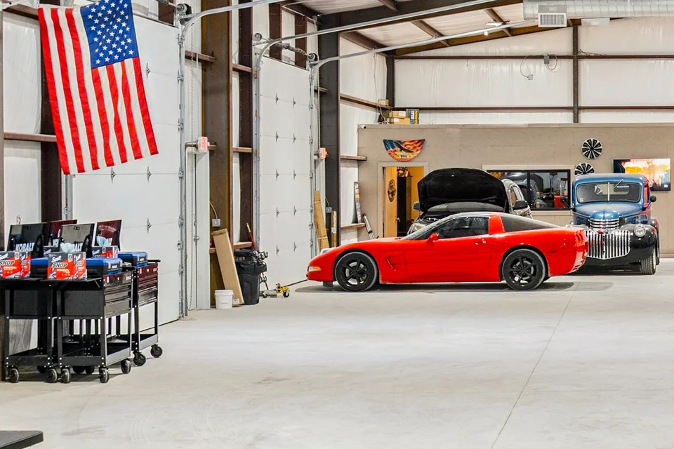 A red Corvette and a classic pickup inside a bay at United Flex Anna