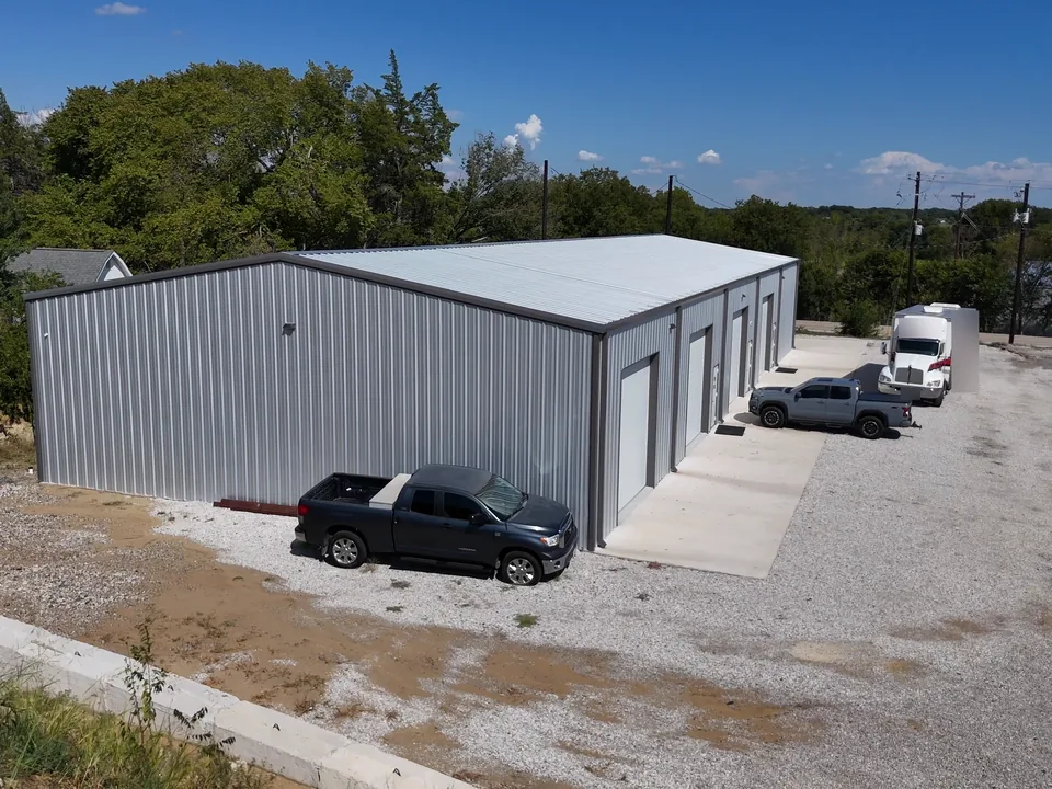 A tall-door shop building and work trucks at United Flex Anna