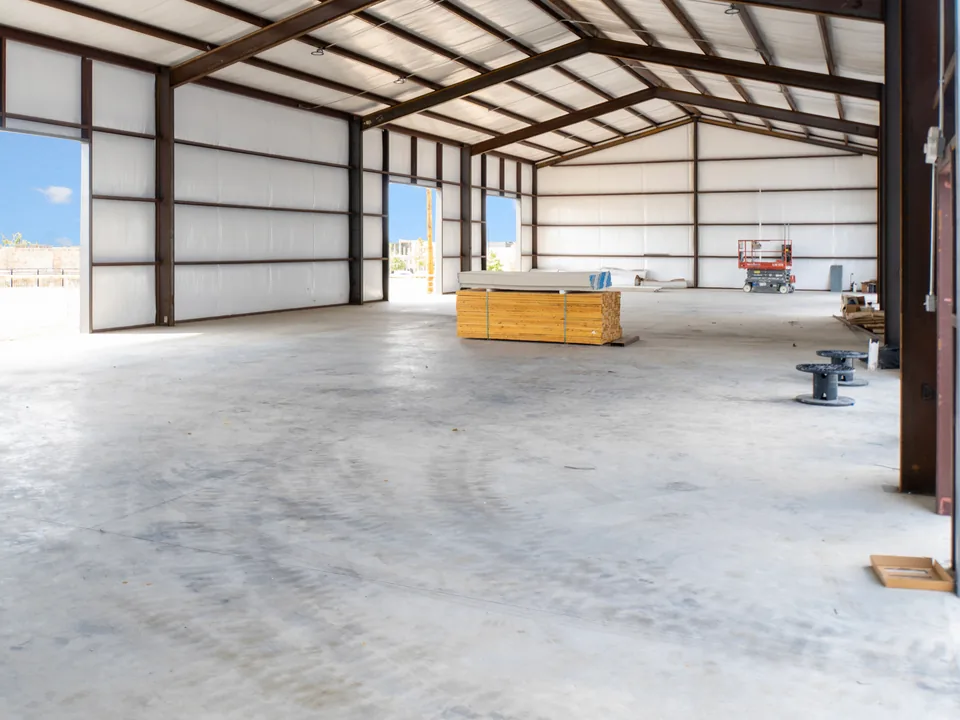 Inside an empty bay at United Flex Melissa: open floor under a clear-span roof