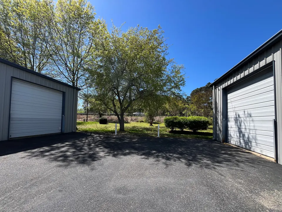 United Flex Toano: white roll-up doors at the ends of two metal buildings on the center drive