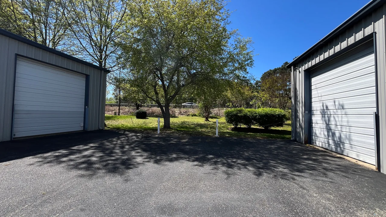 United Flex Toano: white roll-up doors at the ends of two buildings, with a spring tree between them
